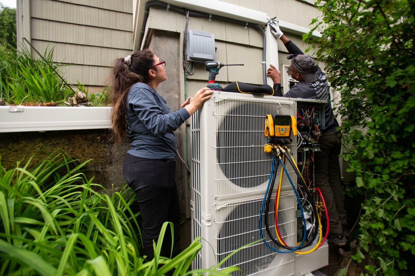 Instalación de bomba de calor en Real Estate: técnicos trabajando en la unidad exterior. Transformando la climatización con tecnología eficiente.