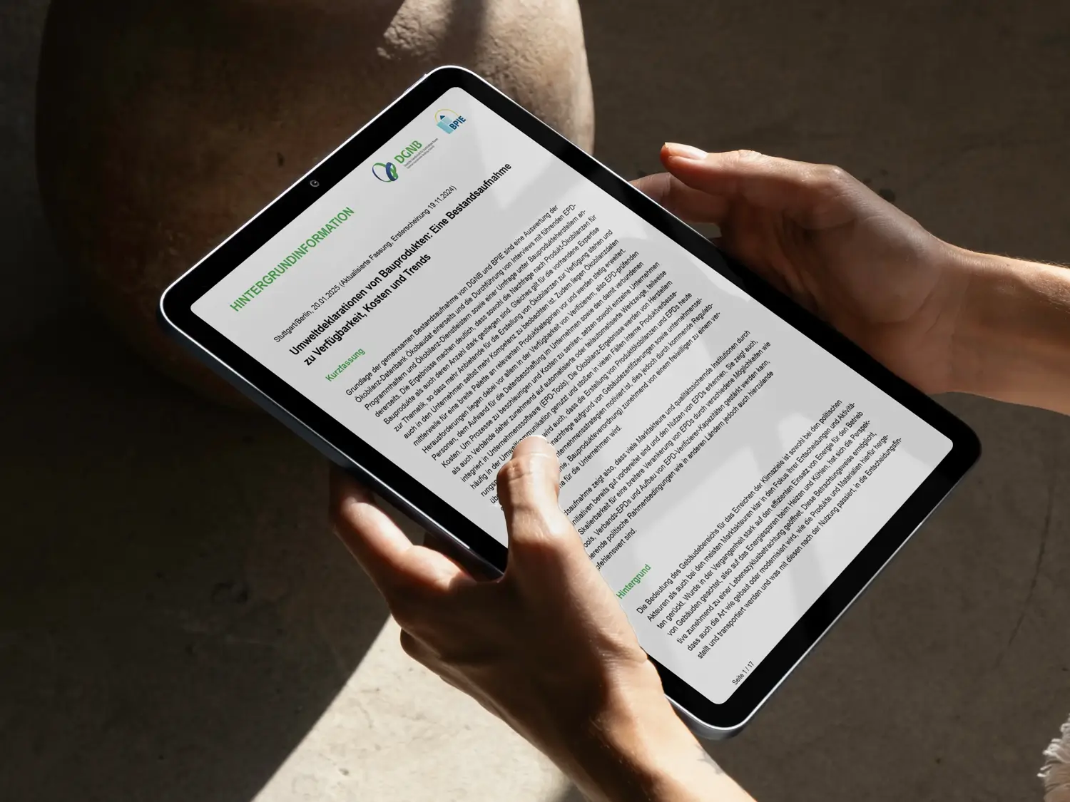 EPDs transformando sector inmobiliario: persona sostiene tablet mostrando informe. Declaraciones ambientales de productos de construcción.