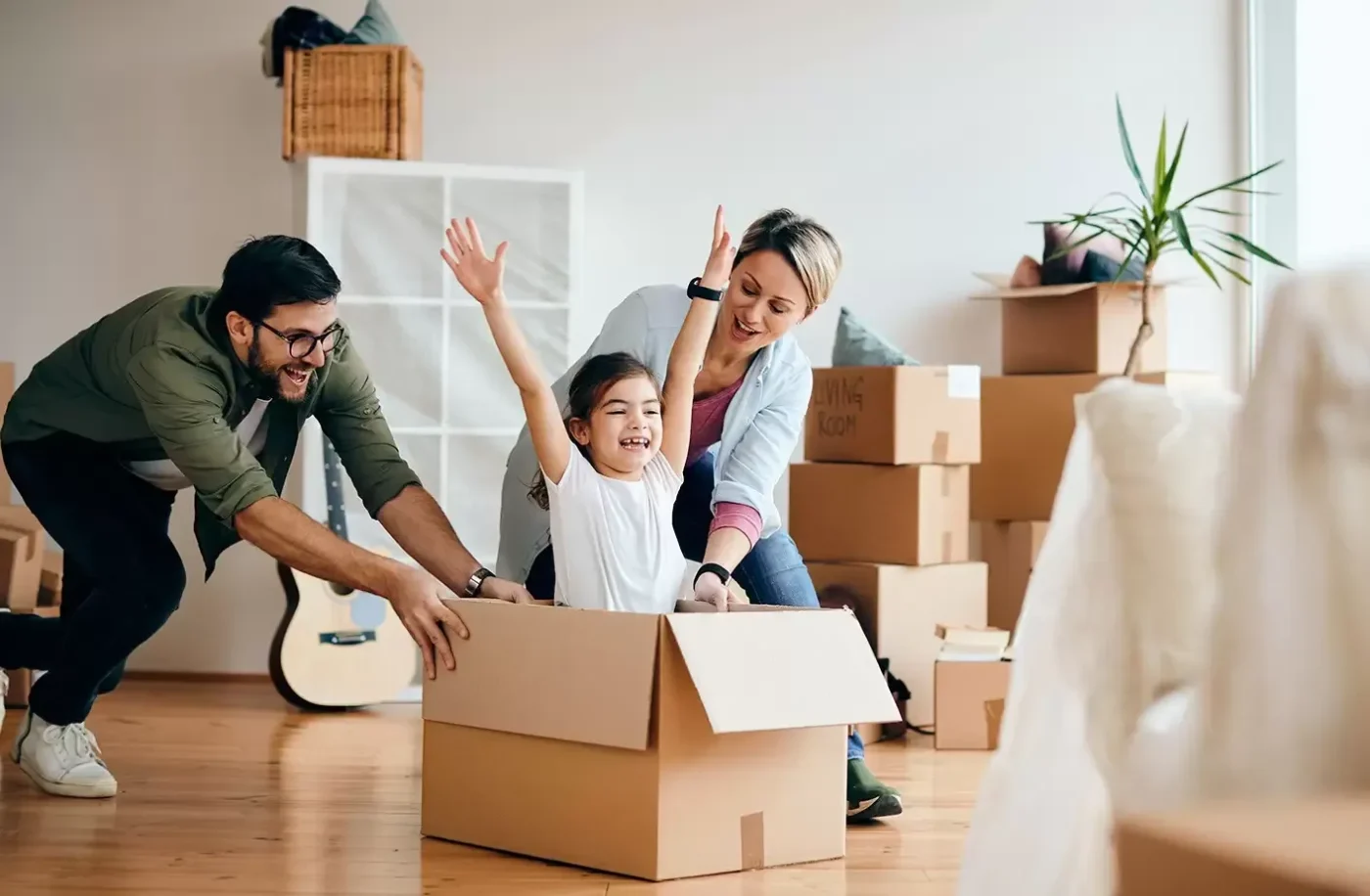 Familia feliz remodelando su vivienda con crédito Infonavit. Niña jugando en caja, padres sonriendo. Crédito Línea 4 para remodelación.