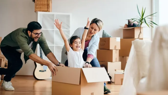 Familia feliz remodelando su vivienda con crédito Infonavit. Niña jugando en caja, padres sonriendo. Crédito Línea 4 para remodelación.