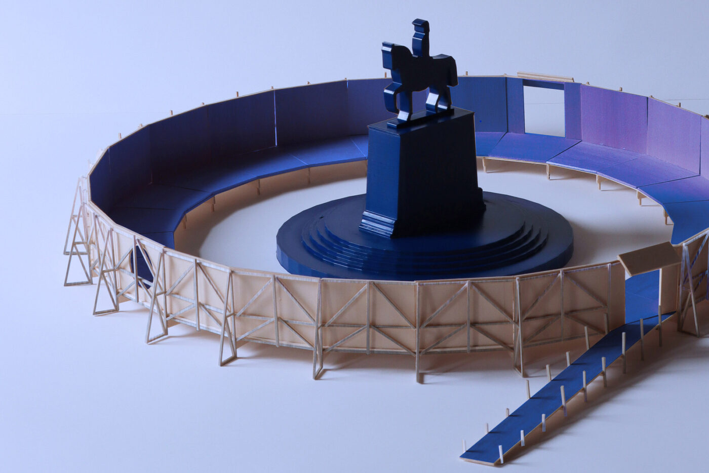 Instalación arquitectónica Concéntrico: estatua ecuestre azul en estructura circular con paredes de madera, parte del festival de arquitectura.