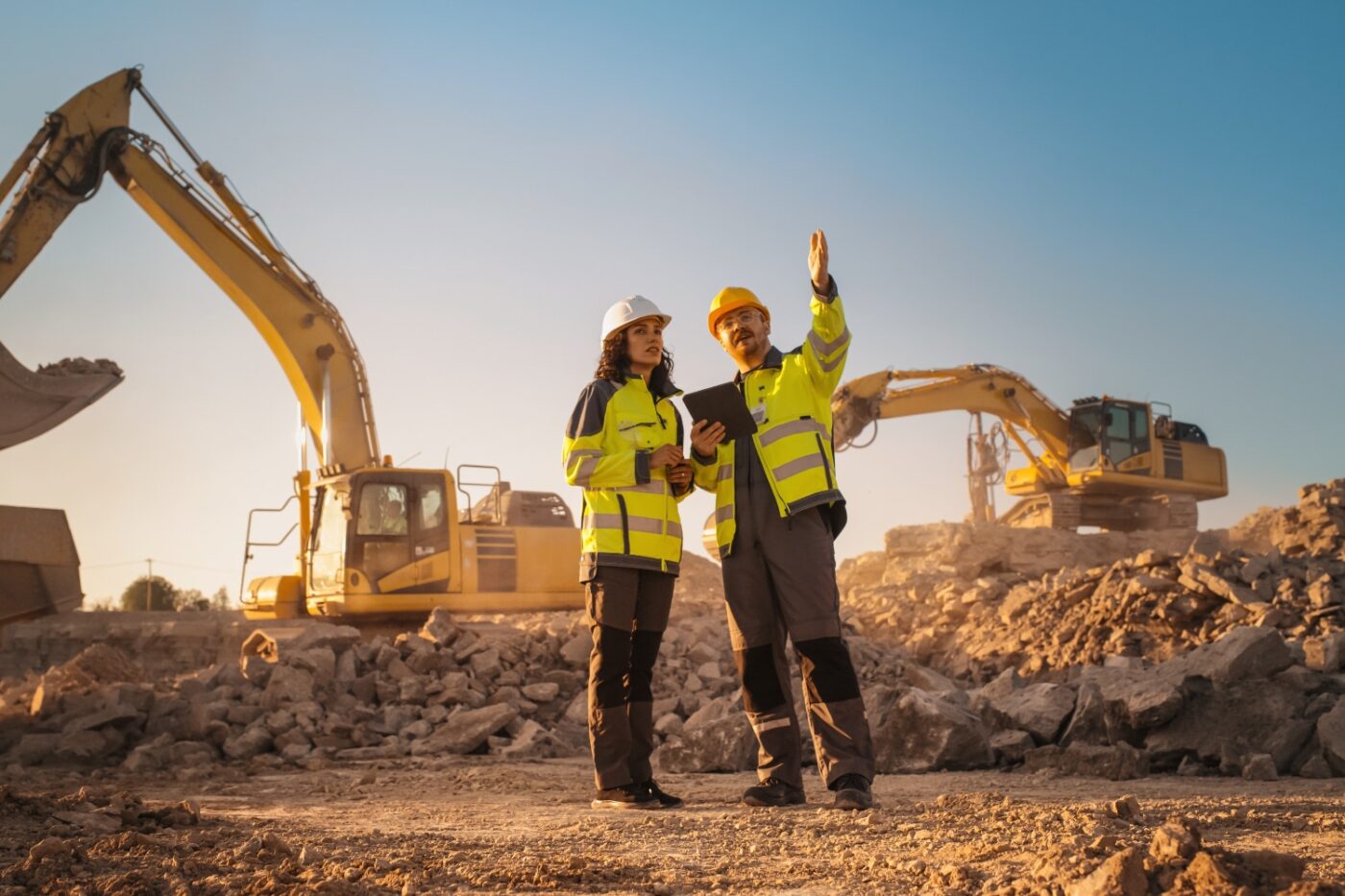venue/architecture

Ingenieros supervisan obra de construcción en México. Excavadoras amarillas en el fondo. Sector inmobiliario en auge.