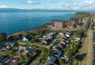 Vista aérea renderizada del Condominio Vista Llanquihue en Chile, con el lago y montañas nevadas al fondo. Próxima construcción inmobiliaria.