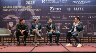 Panel discussion with four men on stage at a business conference.
