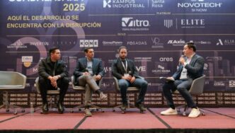 Panel discussion with four men on stage at a business conference.