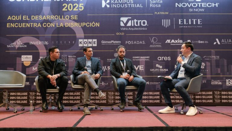 Panel discussion with four men on stage at a business conference.