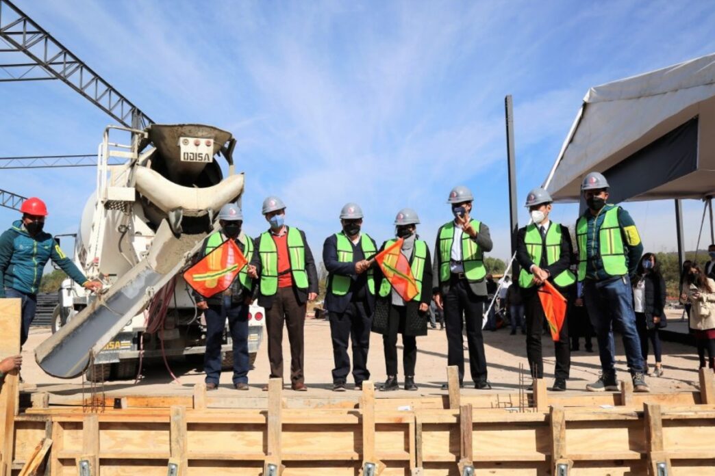 venue/architecture
Colado de cimientos en evento de Inmobiliare Summits, México. Personal con chalecos y banderas en obra. Conferencia real estate LATAM.