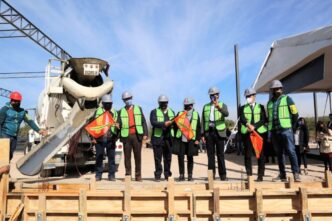 venue/architecture
Colado de cimientos en evento de Inmobiliare Summits, México. Personal con chalecos y banderas en obra. Conferencia real estate LATAM.