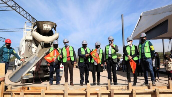 venue/architecture
Colado de cimientos en evento de Inmobiliare Summits, México. Personal con chalecos y banderas en obra. Conferencia real estate LATAM.