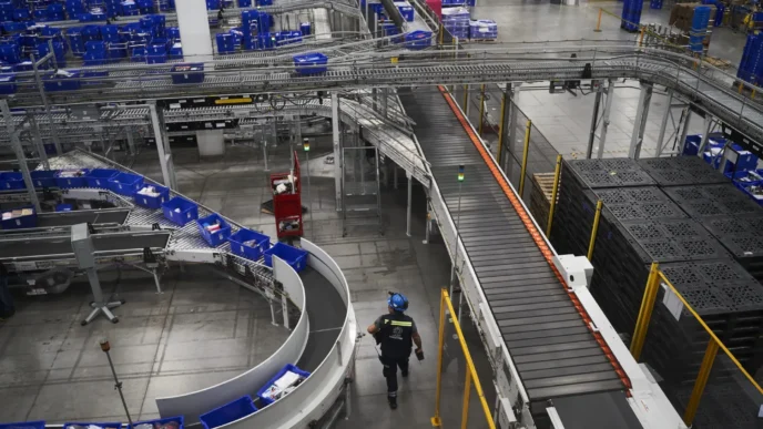 venue/architecture
Vista aérea de la logística moderna en México, un tema clave en Inmobiliare Summits. Bandas transportadoras y operario reflejan la eficiencia del real estate industrial.