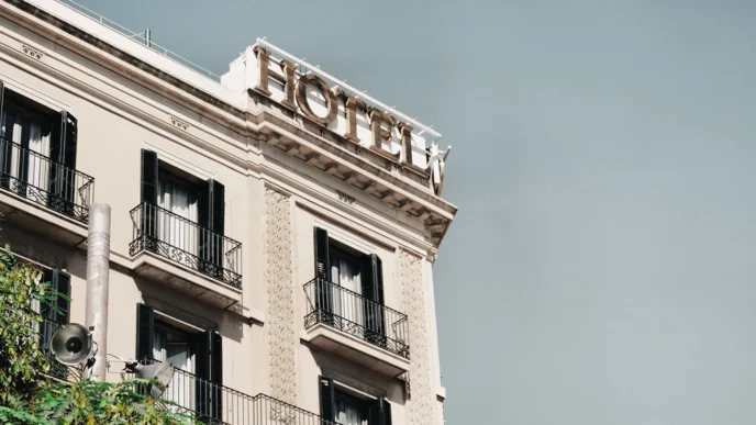 venue/architecture
Fachada de hotel en España, posible sede de Inmobiliare Summits. Arquitectura clásica con balcones y letrero dorado. Sector inmobiliario.