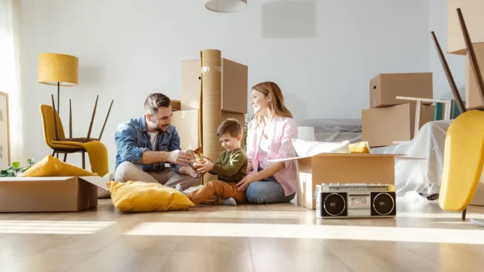 Familia desempaquetando en su nueva casa comprada con crédito hipotecario online. Alegría y emoción en la nueva forma de comprar casa.