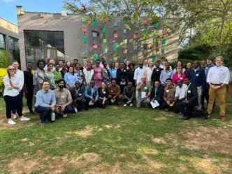 Grupo de asistentes posa en Inmobiliare Summits, evento de real estate LATAM. Networking en la conferencia, en un venue con macetas colgantes.