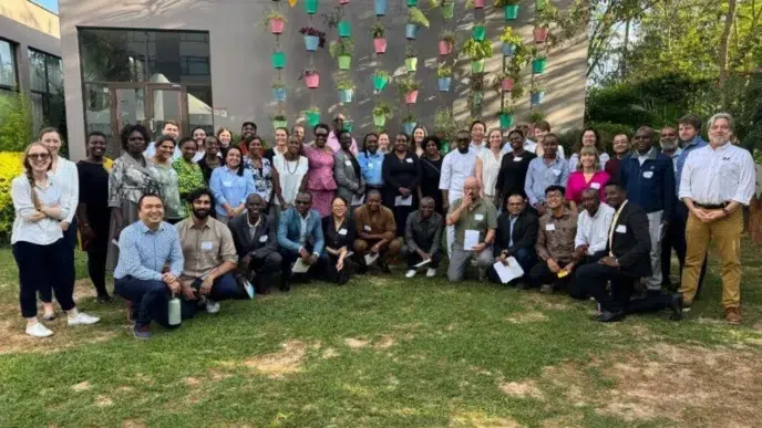 Grupo de asistentes posa en Inmobiliare Summits, evento de real estate LATAM. Networking en la conferencia, en un venue con macetas colgantes.