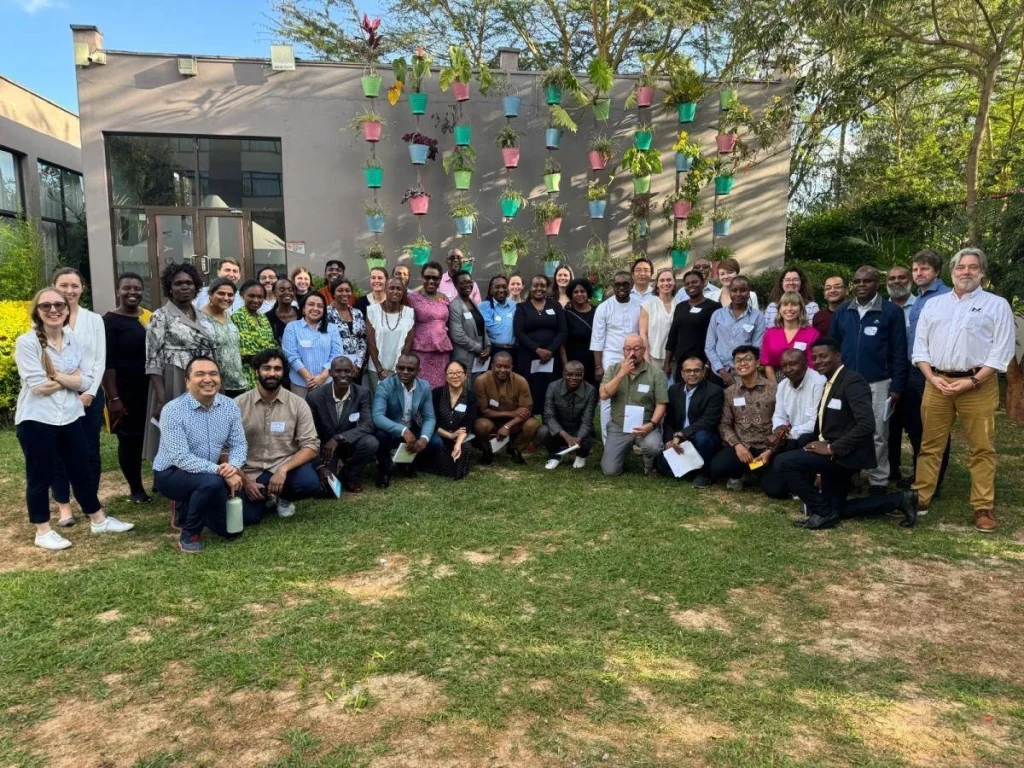 Grupo de asistentes posa en Inmobiliare Summits, evento de real estate LATAM. Networking en la conferencia, en un venue con macetas colgantes.