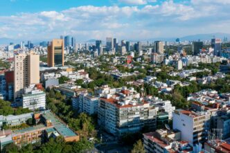 Vista aérea de la Ciudad de México, mostrando edificios y zonas arboladas. Análisis de alcaldías más seguras para vivir en CDMX. Seguridad en la ciudad.