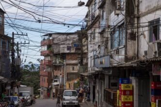 Ciudad de LATAM con cableado aéreo denso. Viviendas precarias en la calle. Estrategia de autoproducción de vivienda en Inmobiliare Summits.