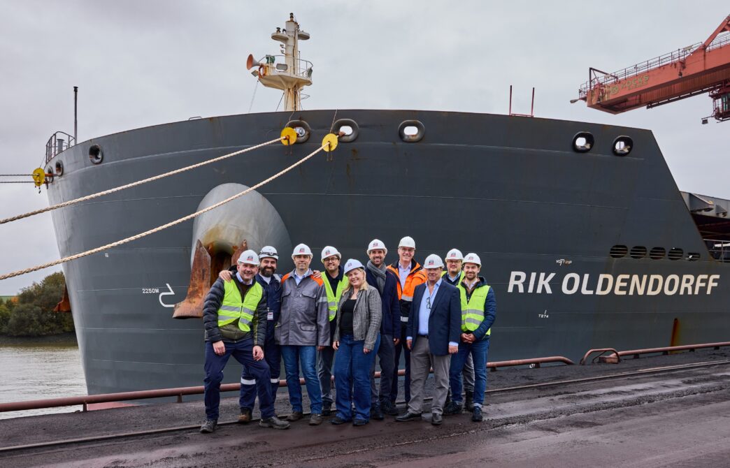 Venue/architecture.

Grupo de personas posa frente al buque RIK OLDENDORFF. Infraestructura portuaria visible.