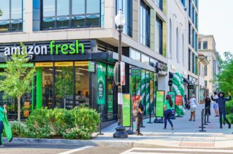 Tienda Amazon Fresh en Glendale con gente esperando. Estrategias de mercado en desinversión y oportunidades visibles. Fachada moderna y letreros verdes.