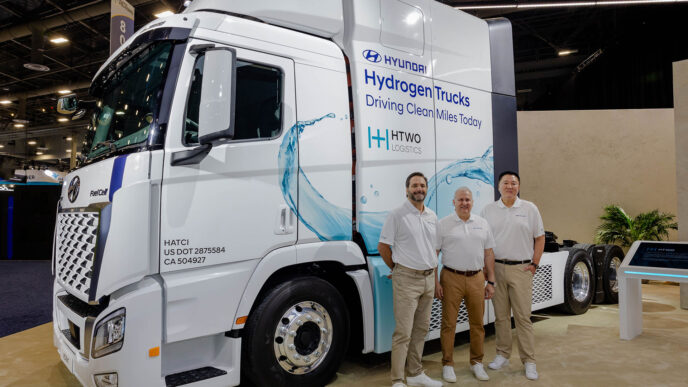 Despliegue de camión Hyundai a hidrógeno con tres personas, redefine movilidad sostenible con Hydrogen Trucks, HTWO Logistics, conducción limpia y FuelCell.