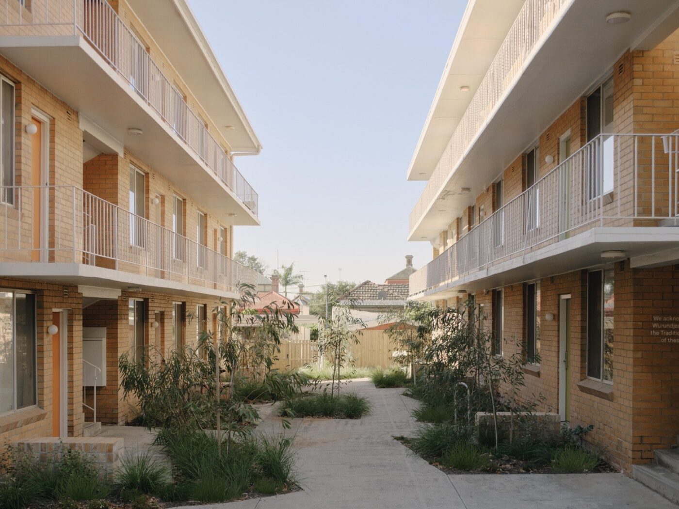 Diseño de Interiores Sostenible para Park Street Apartments: Vista exterior de los apartamentos con balcones y jardines. Arquitectura moderna y ecológica