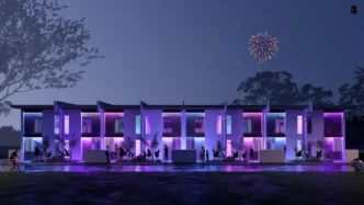 Real Estate Filipinas: Fachada nocturna iluminada de viviendas modernas con personas, reflejo y fuegos artificiales. E-Movilidad transformadora.