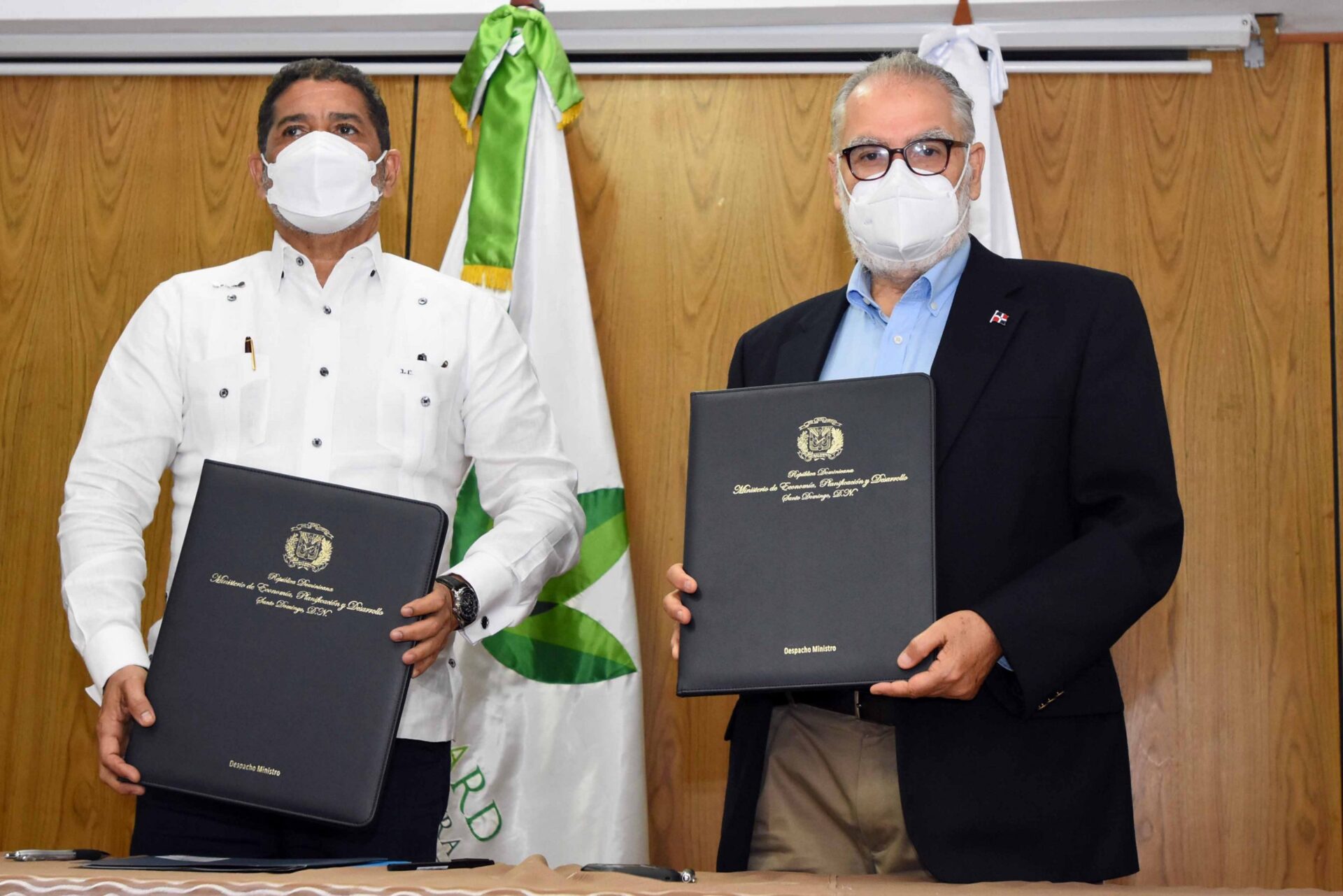 venue/architecture
Dos hombres con mascarillas sostienen documentos firmados. Acuerdo CMIC Jalisco y Sedeco. Impulso al desarrollo inmobiliario.