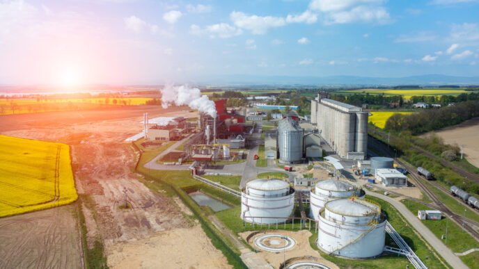 Vista aérea de planta de biofuel, tanques y campos. Impacto en el real estate sostenible. Proceso de energía renovable en el paisaje.