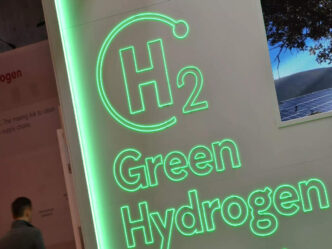 Imagen de neón verde con el símbolo H2 y texto "Green Hydrogen". Concepto de energía sostenible para el Real Estate y el impacto ambiental.