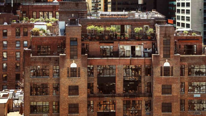 Edificio de ladrillo en NYC con plantas en la azotea, reflejando el impacto de la Ley Local 97 en el real estate. Arquitectura y sostenibilidad urbana.