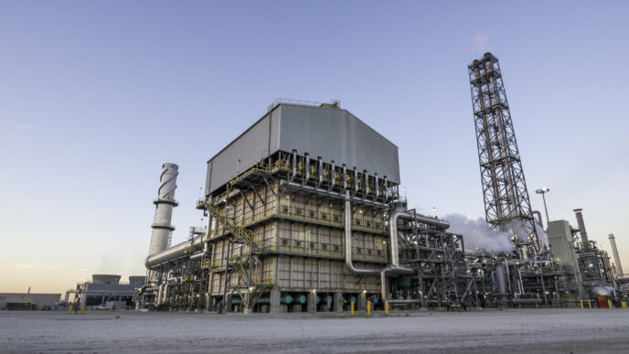 Vista de la planta de amoníaco Blue Point, con tecnología verde. Estructuras industriales, tuberías y chimeneas bajo un cielo despejado. Impacto tecnológico.