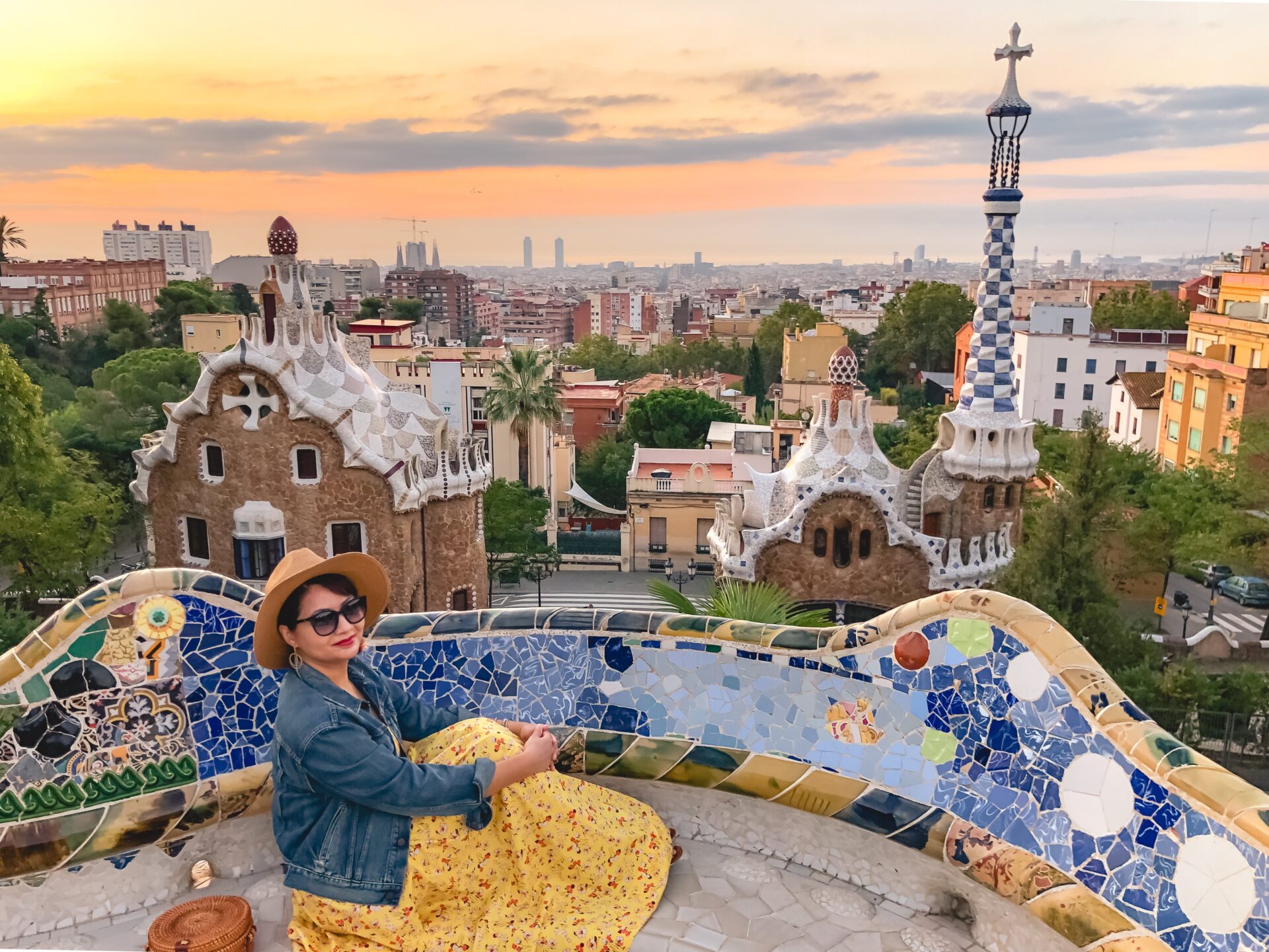 Mujer disfrutando del lujo arquitectónico en el Park Güell, Barcelona. Estilo único de Gaudí con mosaicos y vistas panorámicas de la ciudad.