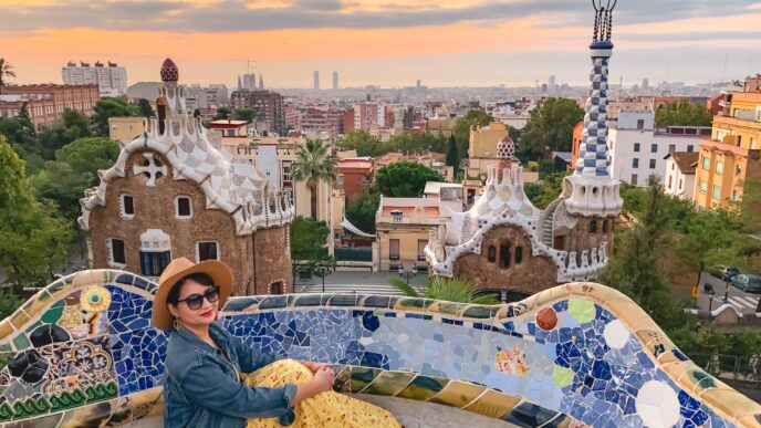 Mujer disfrutando del lujo arquitectónico en el Park Güell, Barcelona. Estilo único de Gaudí con mosaicos y vistas panorámicas de la ciudad.