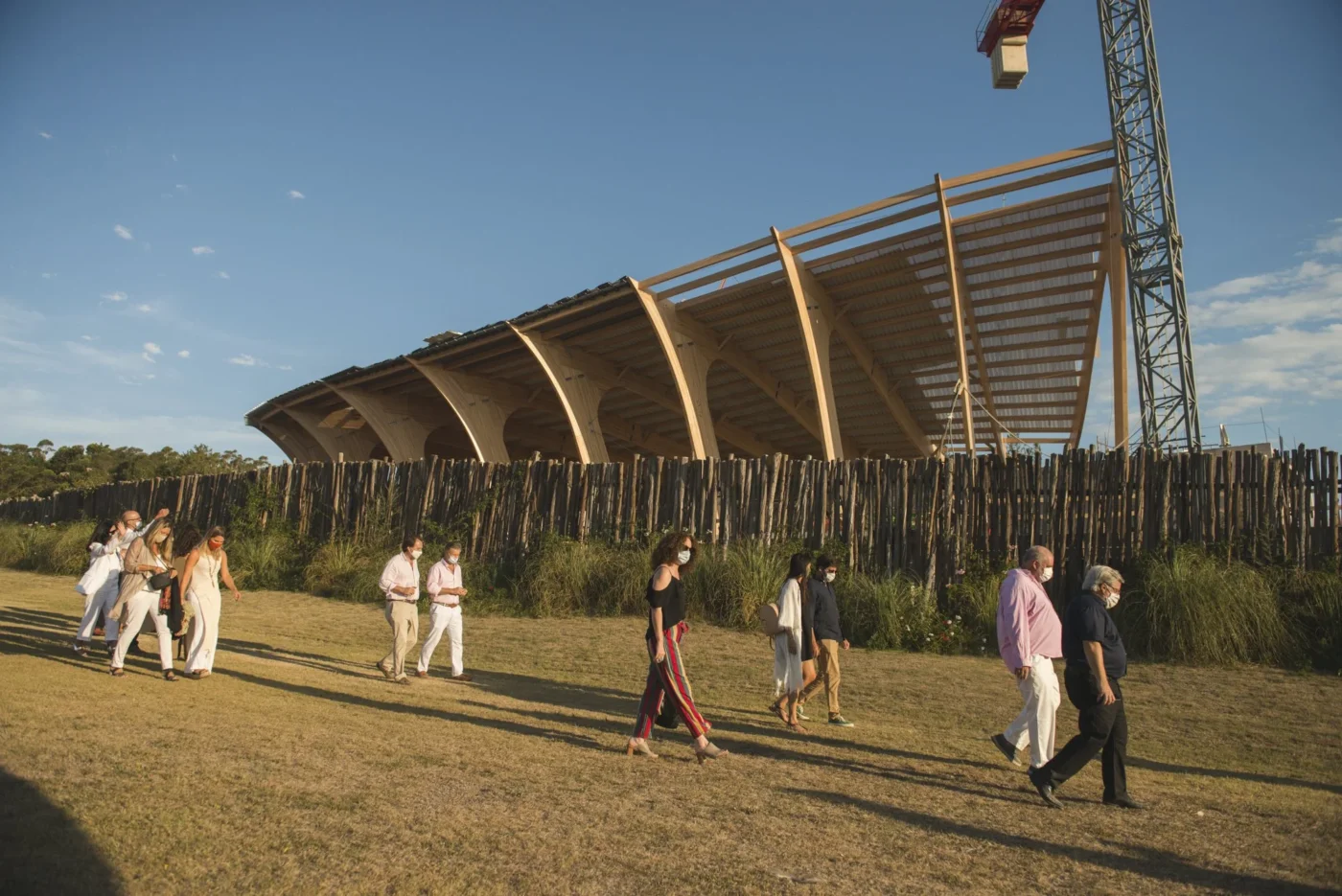 Visitantes recorren el MACA de Uruguay, museo orgánico en construcción. Arquitectura de madera fusionada con el entorno natural. Obra en progreso.