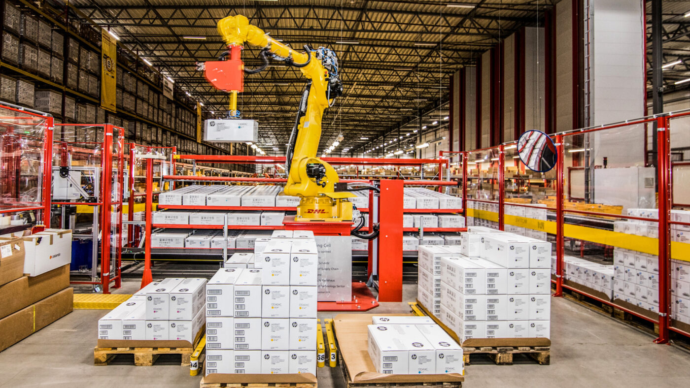 venue/architecture

Brazo robótico amarillo de DHL moviendo cajas en un almacén. Automatización y logística avanzada.