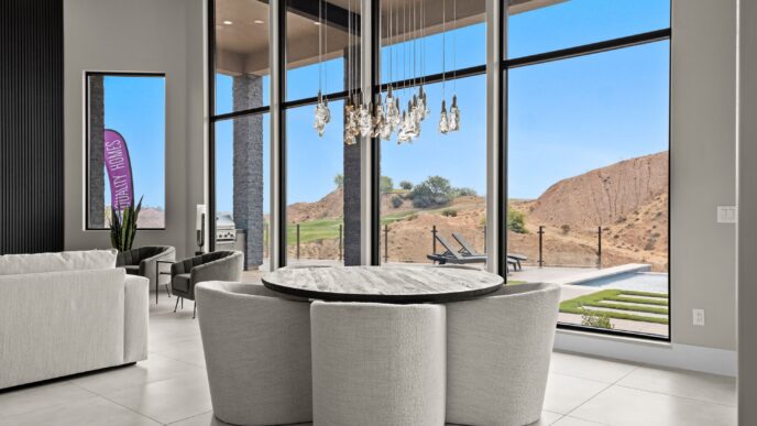 Interior de lujo con mesa redonda y vistas panorámicas a paisajes desérticos. Inversión en real estate de alto standing y diseño moderno.