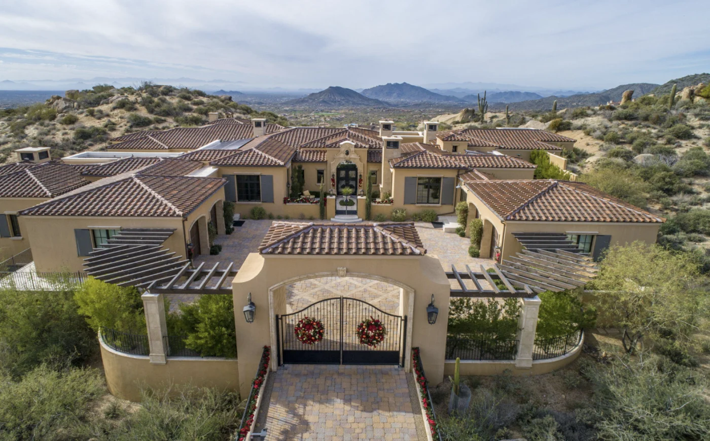 Vista aérea de una lujosa mansión en Paradise Valley, con tejas rojas y entrada adornada. Horizonte de lujo en un entorno natural y exclusivo.