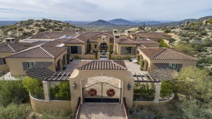 Vista aérea de una lujosa mansión en Paradise Valley, con tejas rojas y entrada adornada. Horizonte de lujo en un entorno natural y exclusivo.