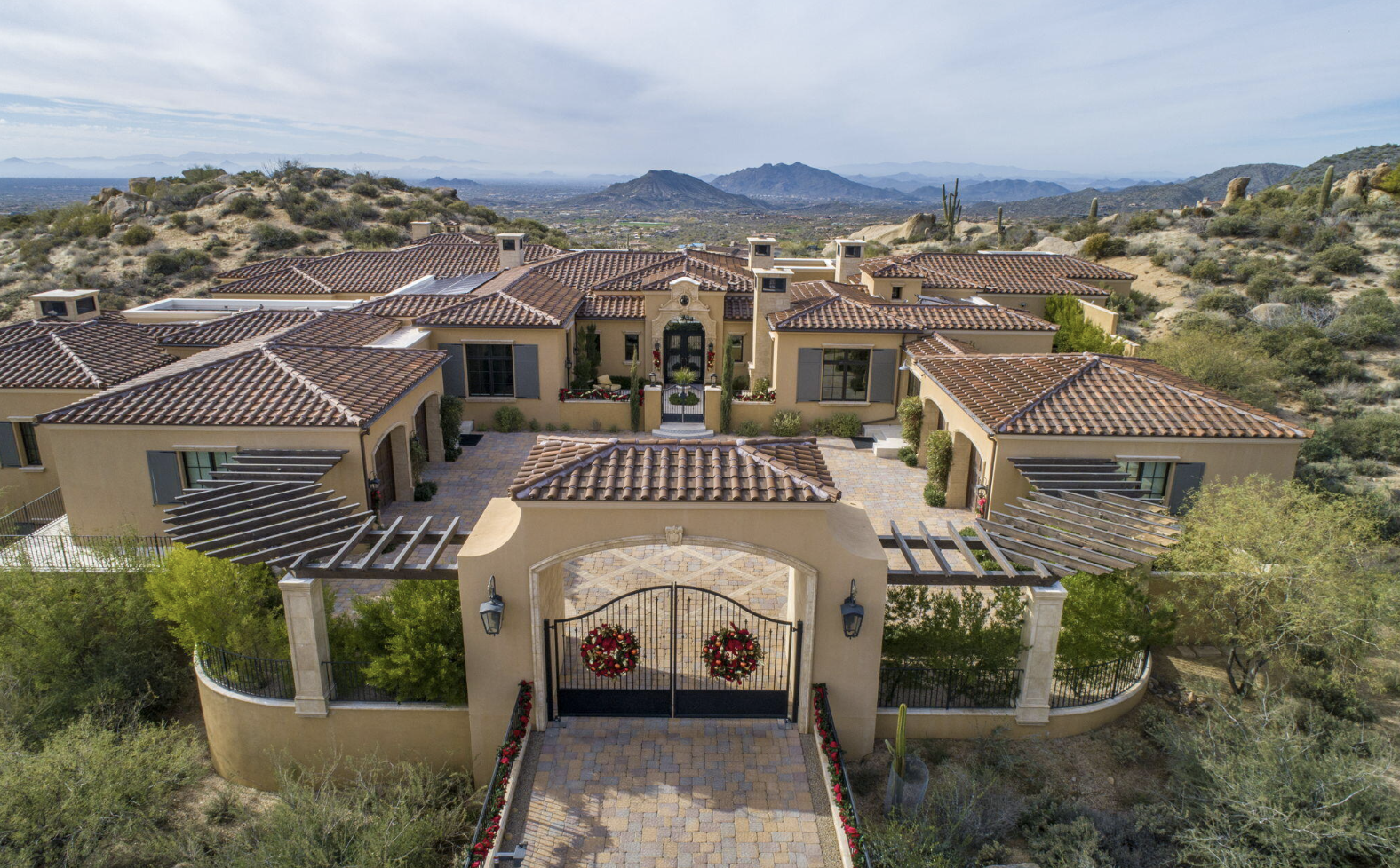 Vista aérea de una lujosa mansión en Paradise Valley, con tejas rojas y entrada adornada. Horizonte de lujo en un entorno natural y exclusivo.