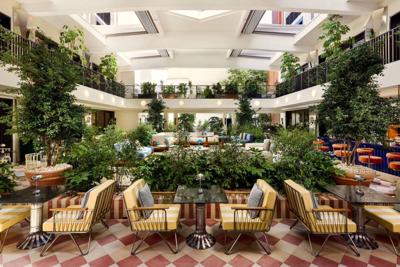 Lujoso interior del W Hoboken, un oasis urbano con vegetación exuberante y mobiliario elegante. Icono de hospitalidad con diseño renovado y exclusivo.