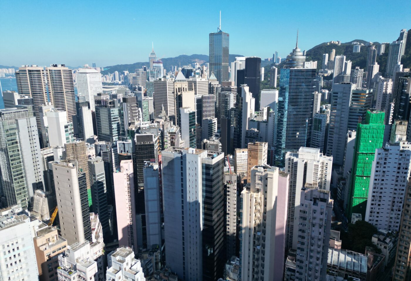 Vista aérea de Hong Kong mostrando el auge del mercado inmobiliario de lujo con rascacielos y edificios modernos bajo un cielo despejado.