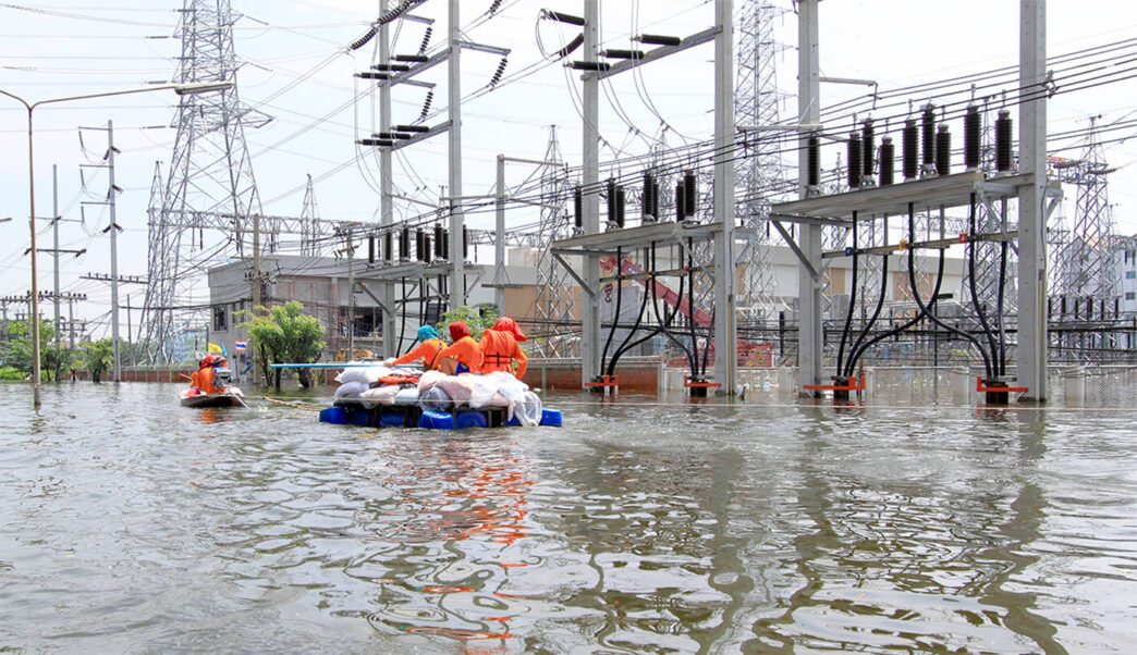 This image does not relate to the keywords or categories provided. I will generate an alt text based on the image content.

Personas en botes navegan inundación cerca de subestación eléctrica. Impacto climático severo en infraestructura urbana.