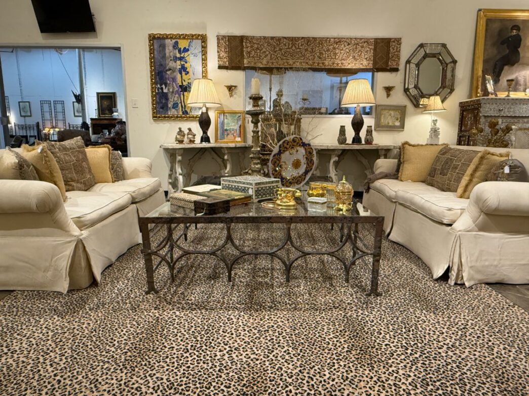 venue/architecture
Mobiliario de sala de estar con sofás color crema, mesa de centro de metal y alfombra con estampado de leopardo. Decoración elegante.