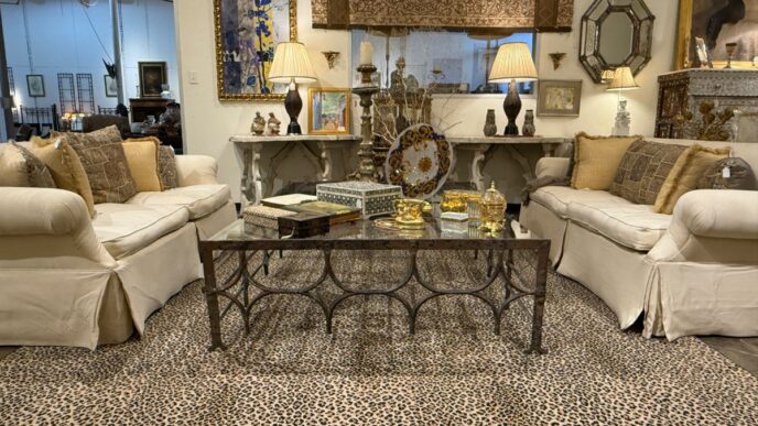 venue/architecture
Mobiliario de sala de estar con sofás color crema, mesa de centro de metal y alfombra con estampado de leopardo. Decoración elegante.