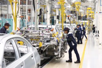 The image does not depict any of the specified categories. I will try my best.

Trabajadores ensamblan automóviles en una fábrica. Industria automotriz en México.