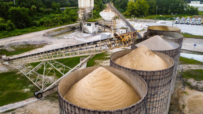 Vista aérea de una planta de cemento sostenible con silos llenos y sistema de transporte. Energía renovable y eficiencia en la producción de cemento.