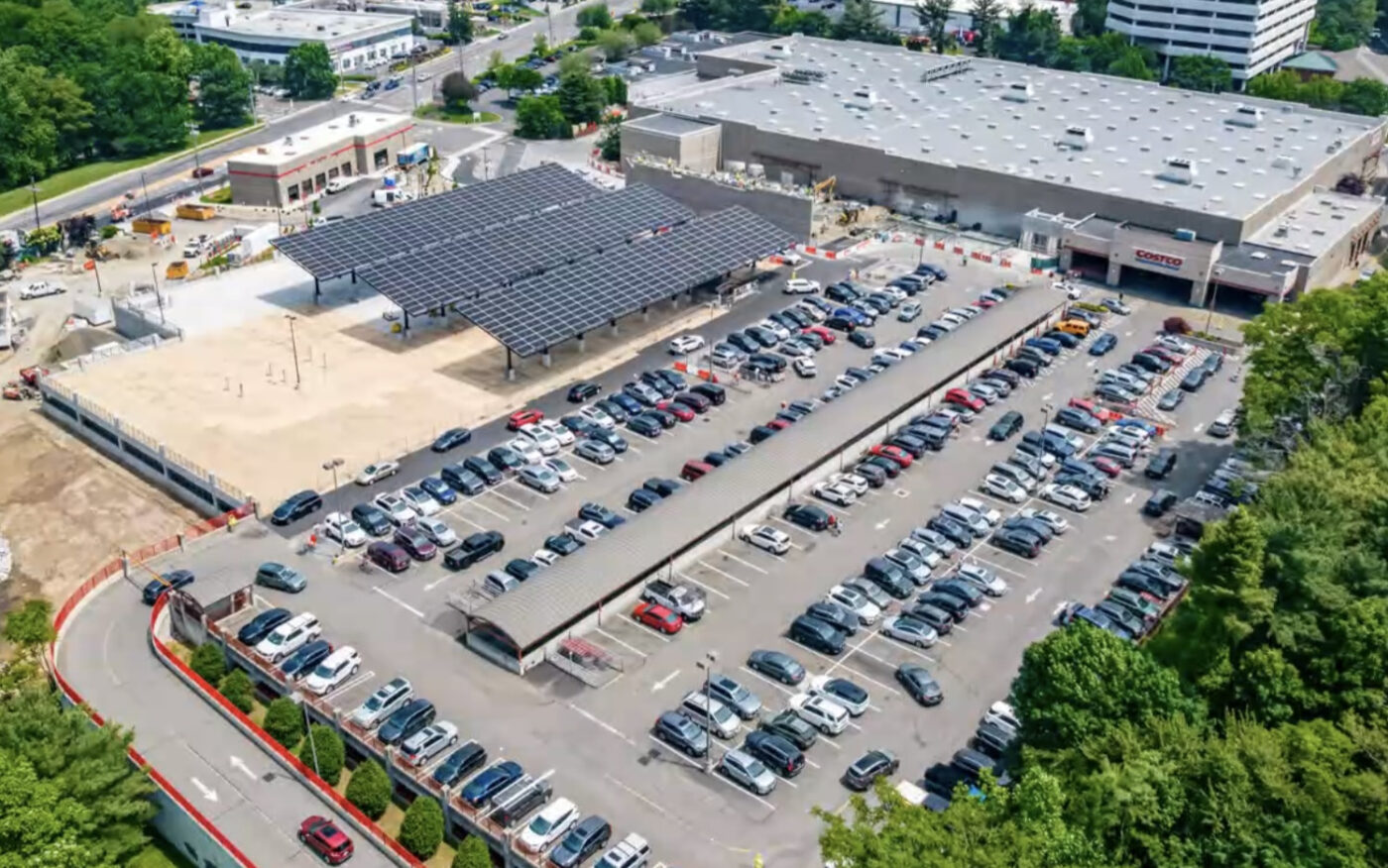 Vista aérea de Costco con estacionamiento cubierto por paneles solares. Energía solar transformando la eficiencia en almacenes de Costco, sostenible.