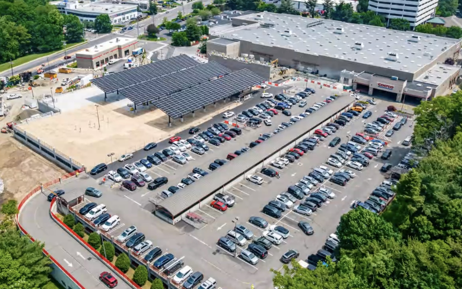 Vista aérea de Costco con estacionamiento cubierto por paneles solares. Energía solar transformando la eficiencia en almacenes de Costco, sostenible.