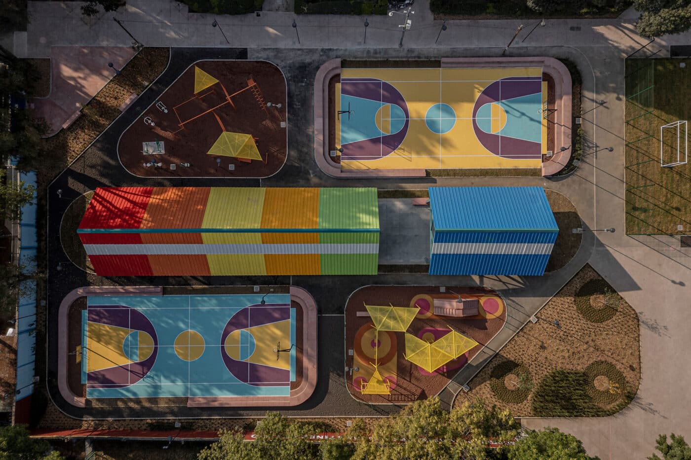 Vista aérea de espacios recreativos para 'Equipa tu Casa' Infonavit: canchas de baloncesto coloridas, juegos infantiles y estructuras modulares con techos vivos.