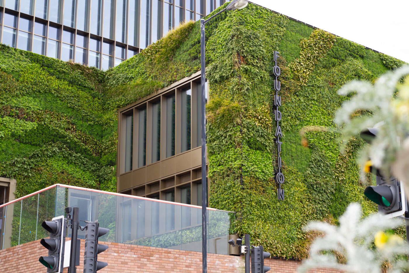 Fachada verde del edificio Foundation en Manchester, ejemplo de espacios sostenibles y Real Estate verde que redefine la arquitectura urbana con vegetación.
